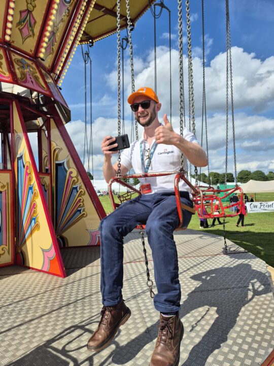 David Sykes films a video for social media by riding on a fairground ride at Lincolnshire Show